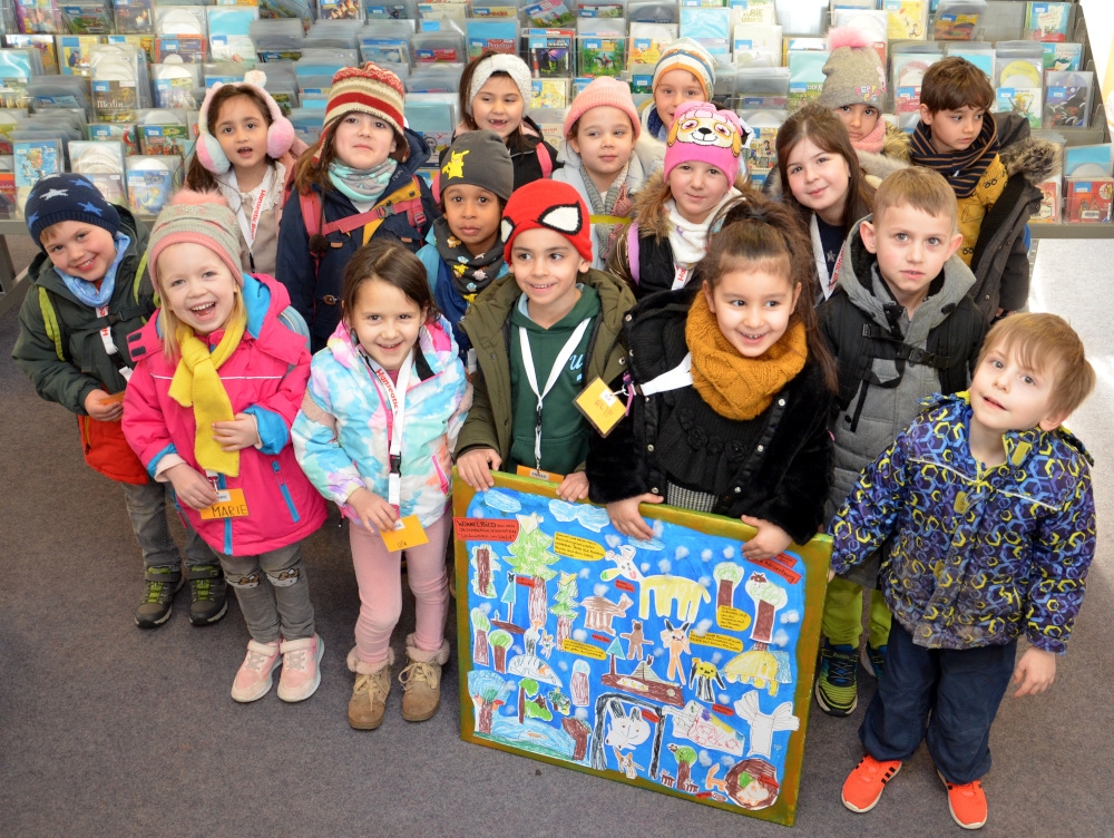 Gruppe mit Kindern zeigen den neuen Wandschmuck