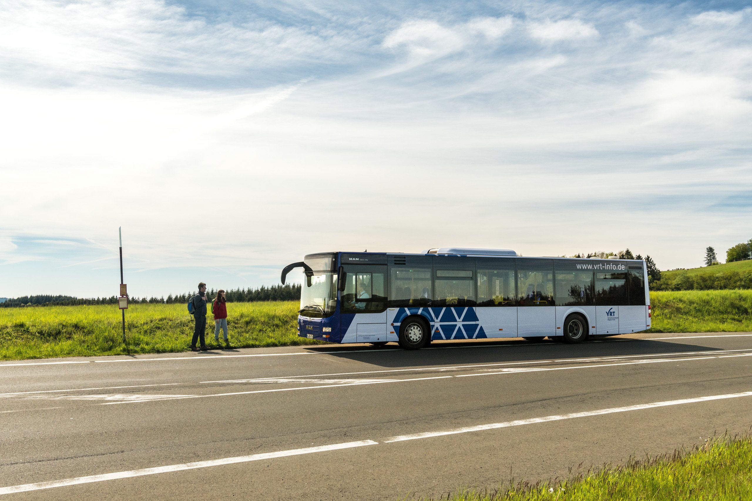Bus vor Haltestelle auf freier Strecke