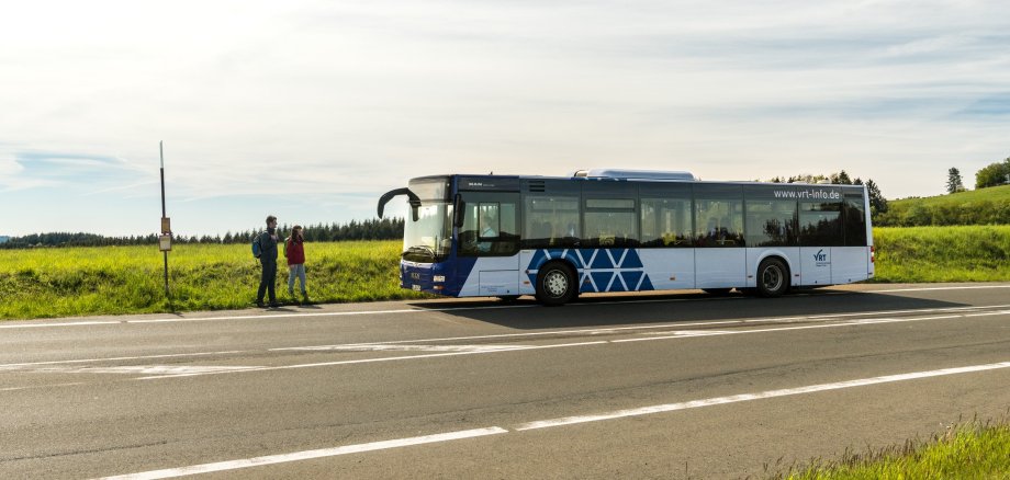 Bus vor Haltestelle auf freier Strecke
