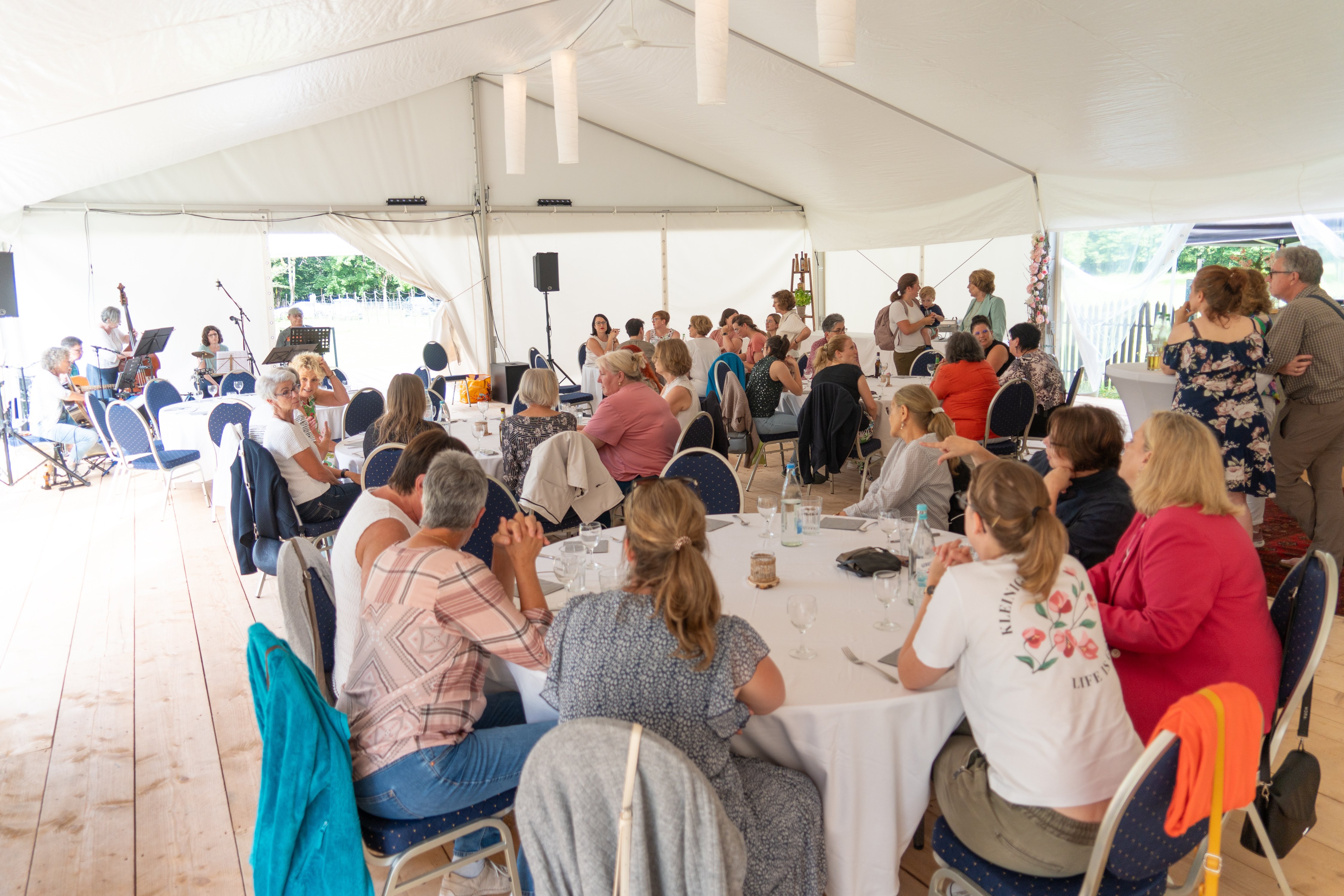 Frauen sitzen in einem festzelt an Tischen
