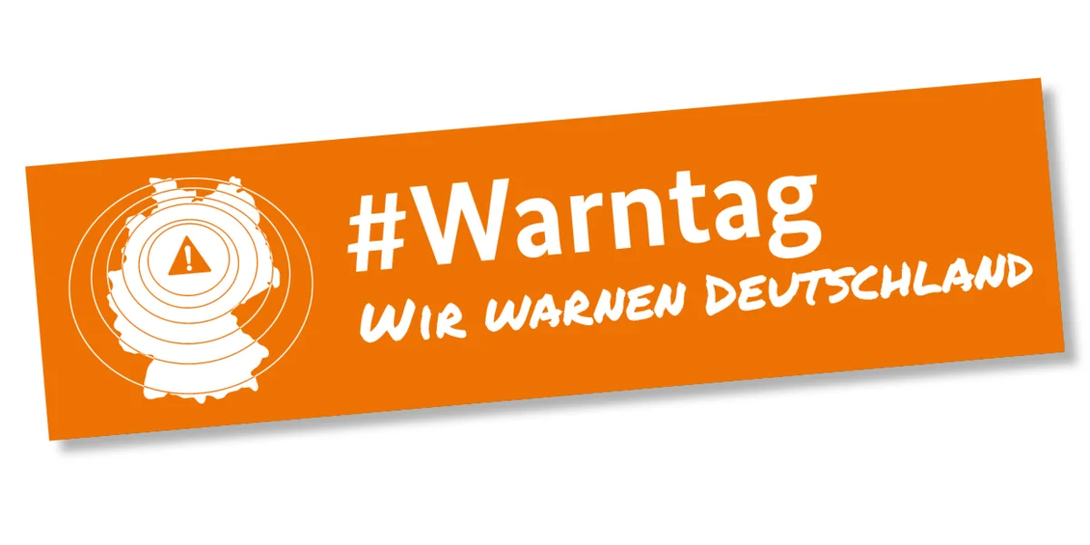 Orangefarbener Banner mit weißem Text „#Warntag – Wir warnen Deutschland“. Links befindet sich eine stilisierte Karte von Deutschland mit konzentrischen Kreisen und einem Warnsymbol (Ausrufezeichen im Dreieck) in der Mitte.